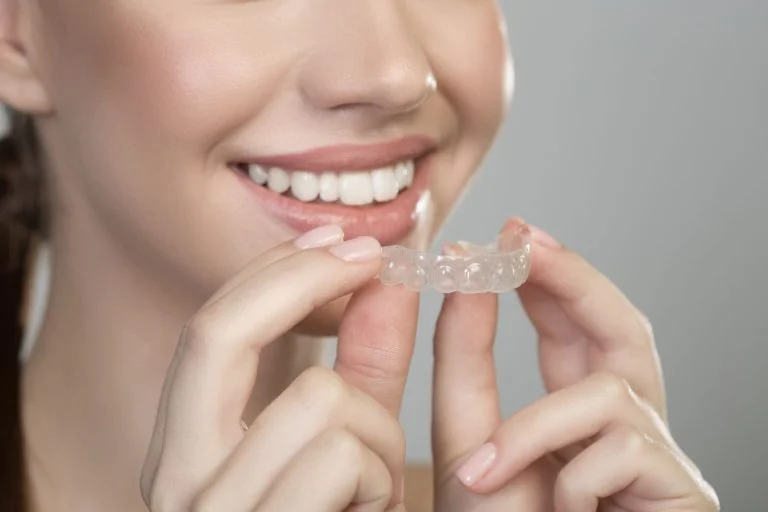 Girl Holding Clear Braces of Star Smiles